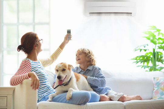 Woman relaxing on couch enjoying cool air from a wall-mounted mini split system